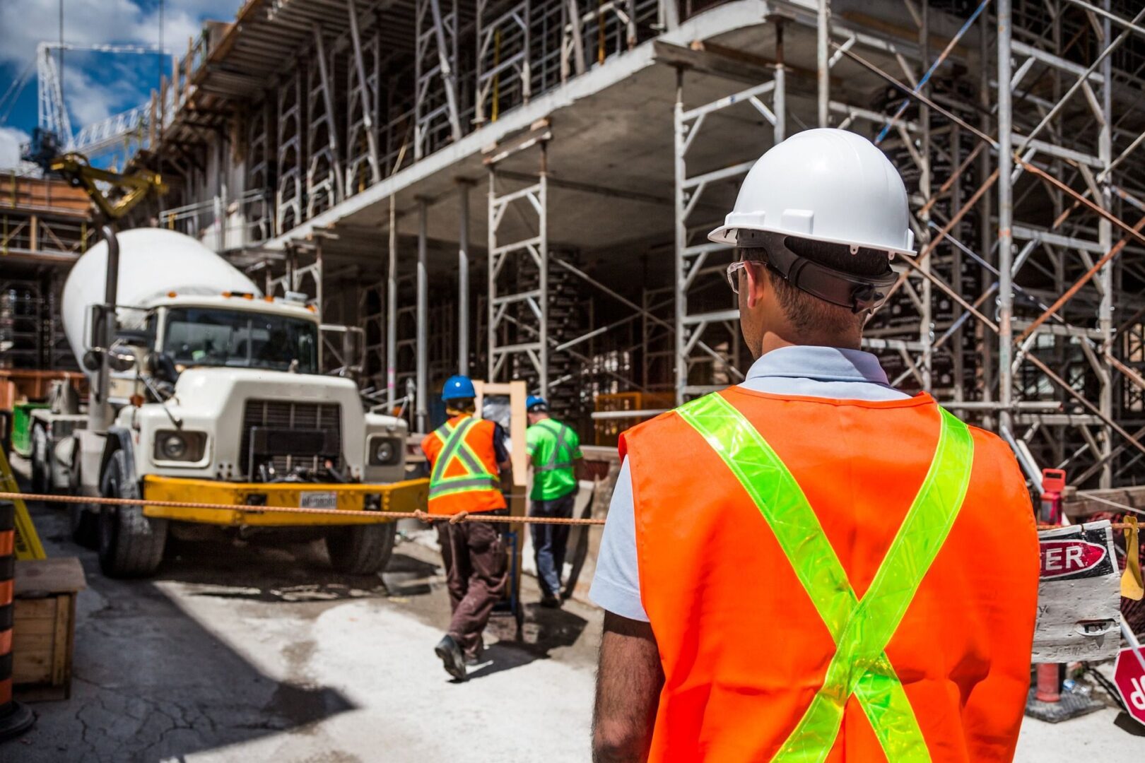 A group of construction workers standing next to a truck.