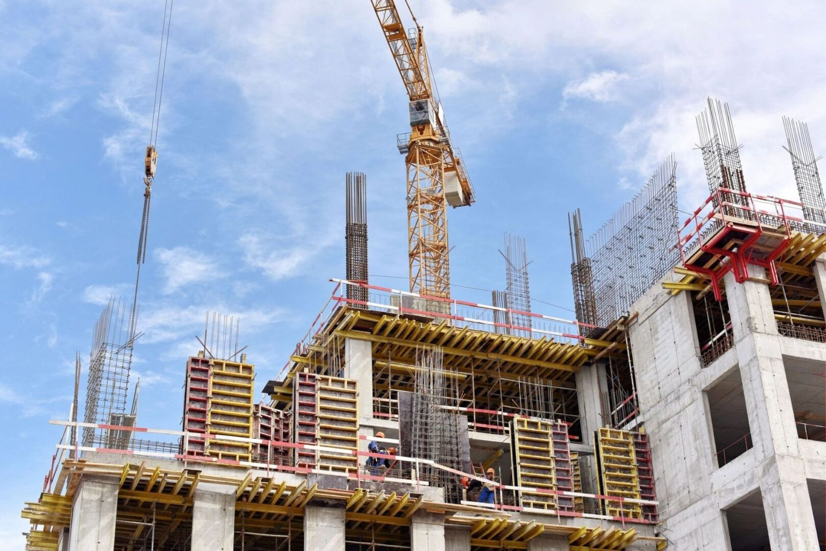 A building under construction with scaffolding and cranes.