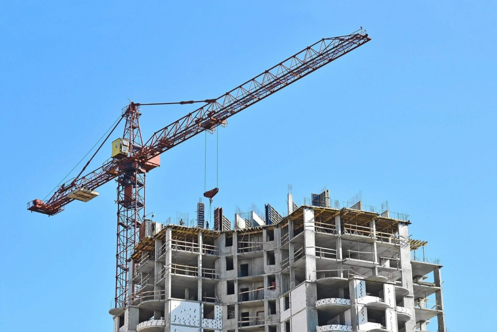 A crane is in front of a building under construction.