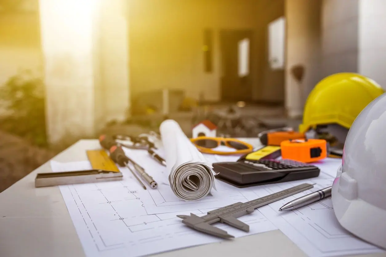 A table with construction tools and papers on it.