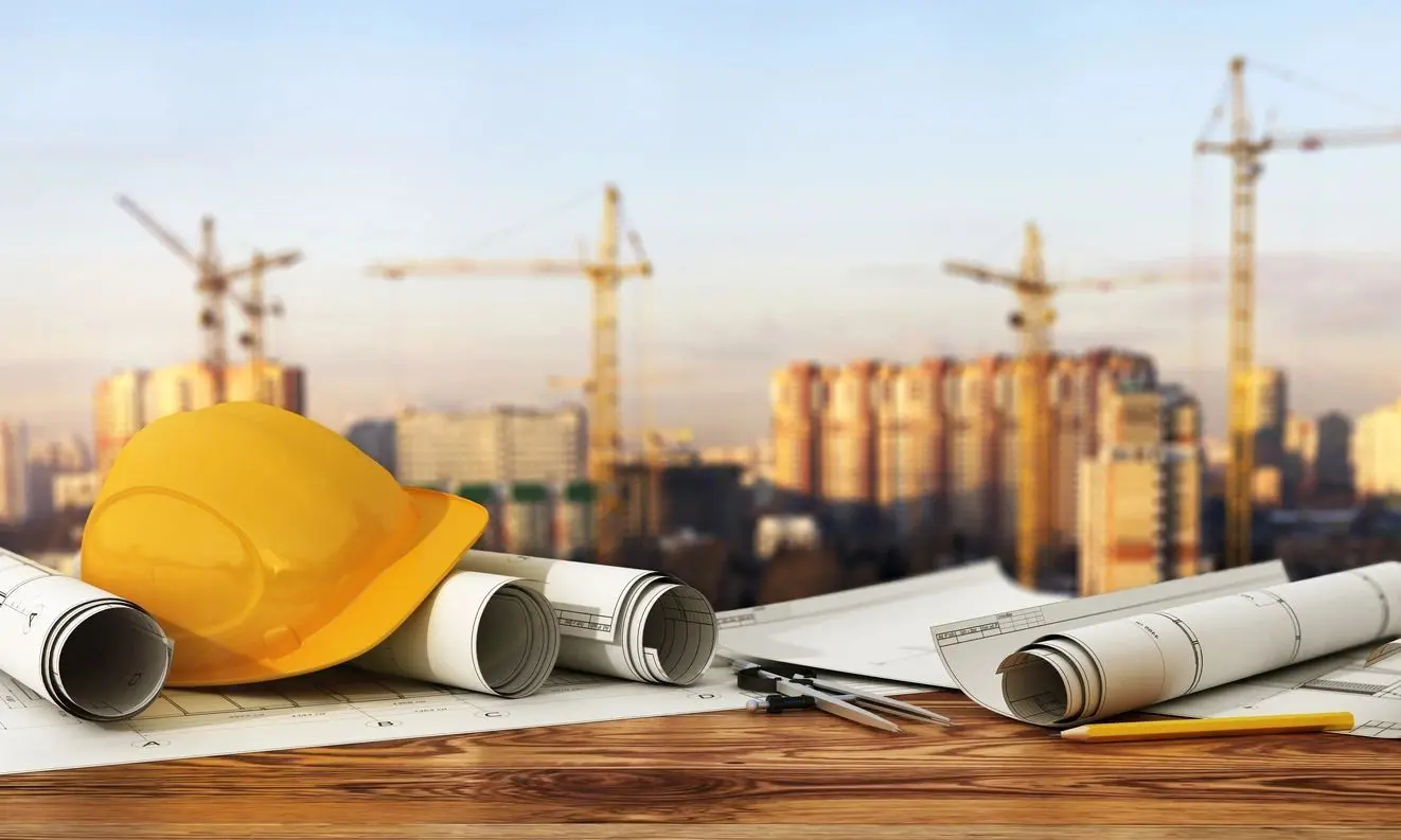 A construction site with some papers and a yellow hard hat