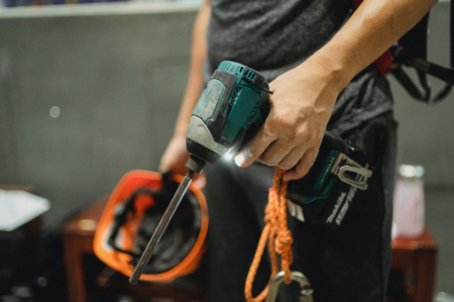 A person holding tools and a flashlight in their hand.