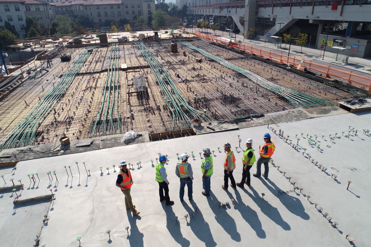 A group of construction workers standing on top of a building.