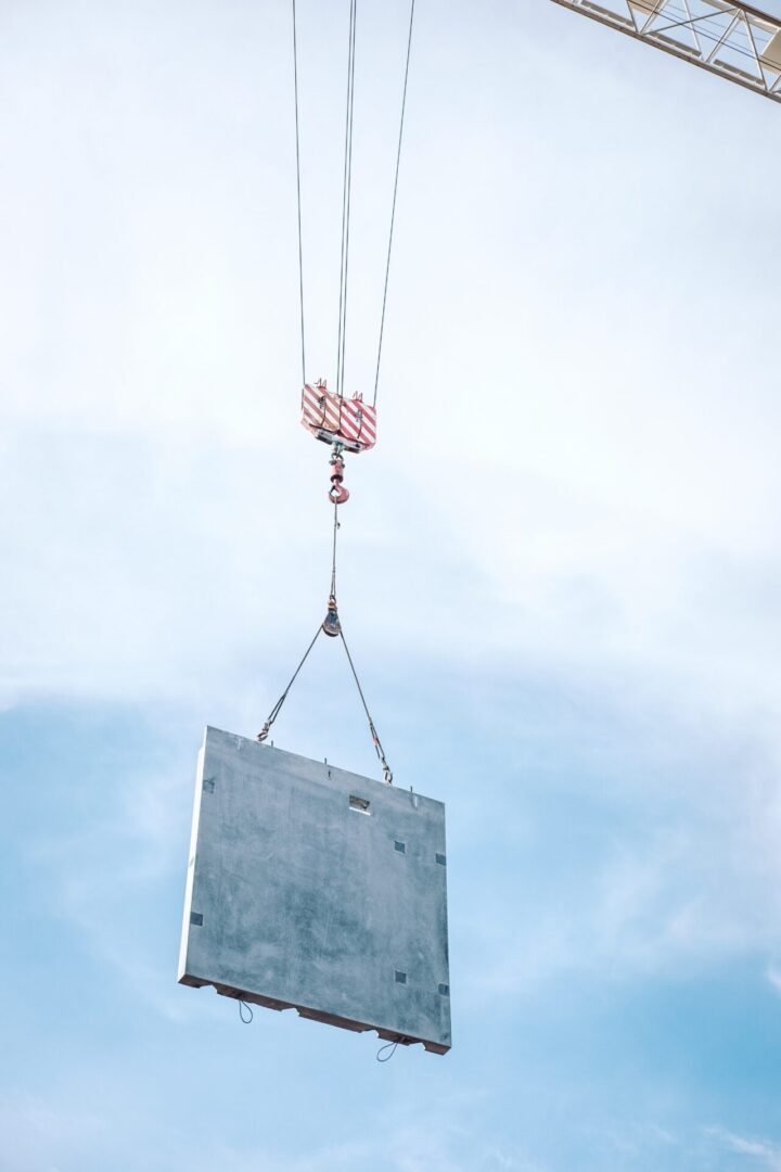 A crane lifting a sign in the air.