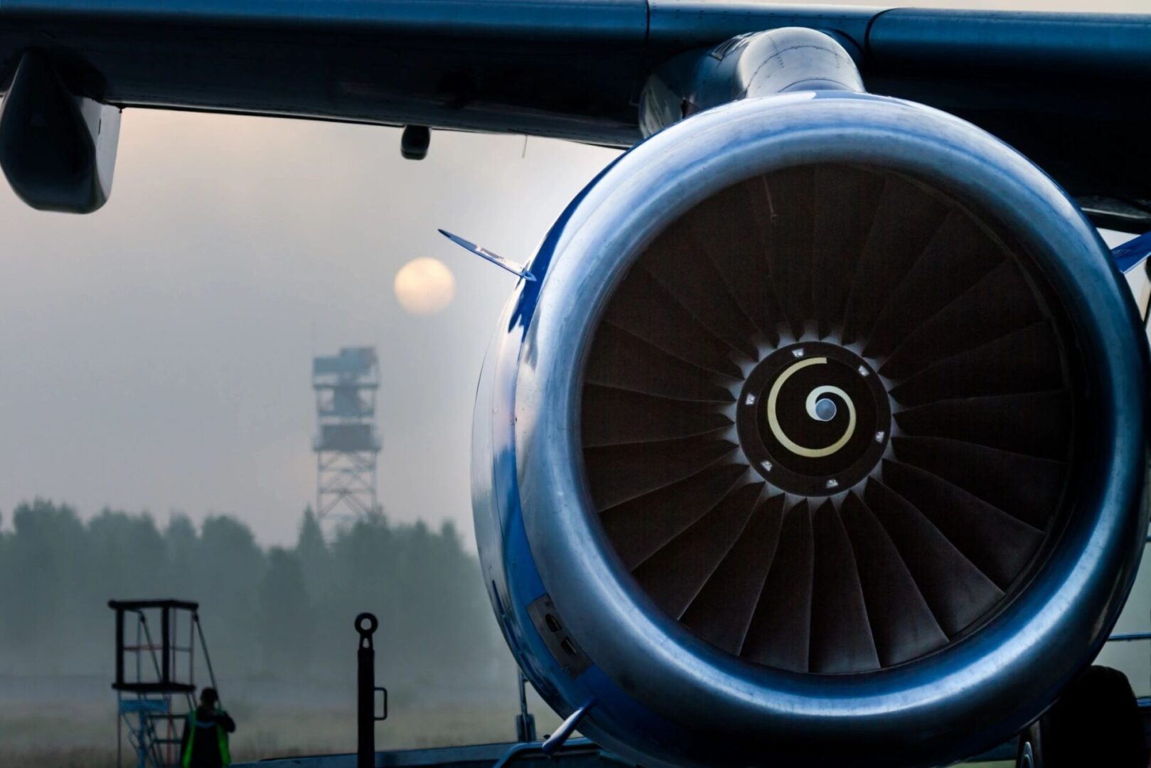 A large jet engine sitting on top of an airport runway.