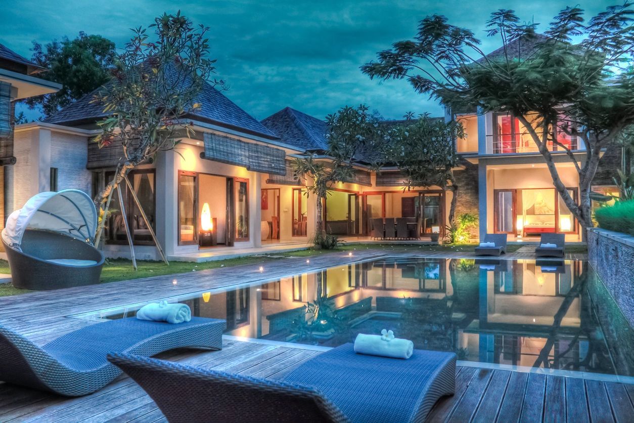 A pool with chairs and lights on the side