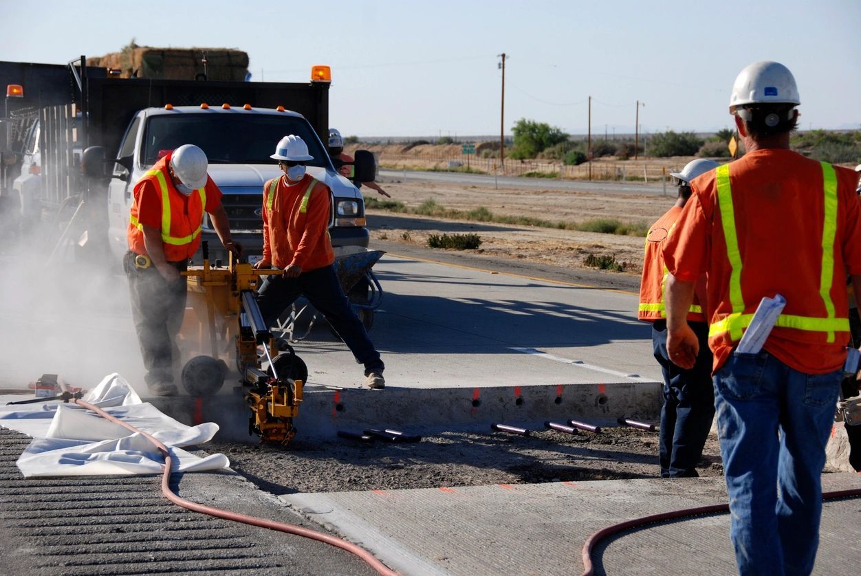 A group of men working on the side of a road.